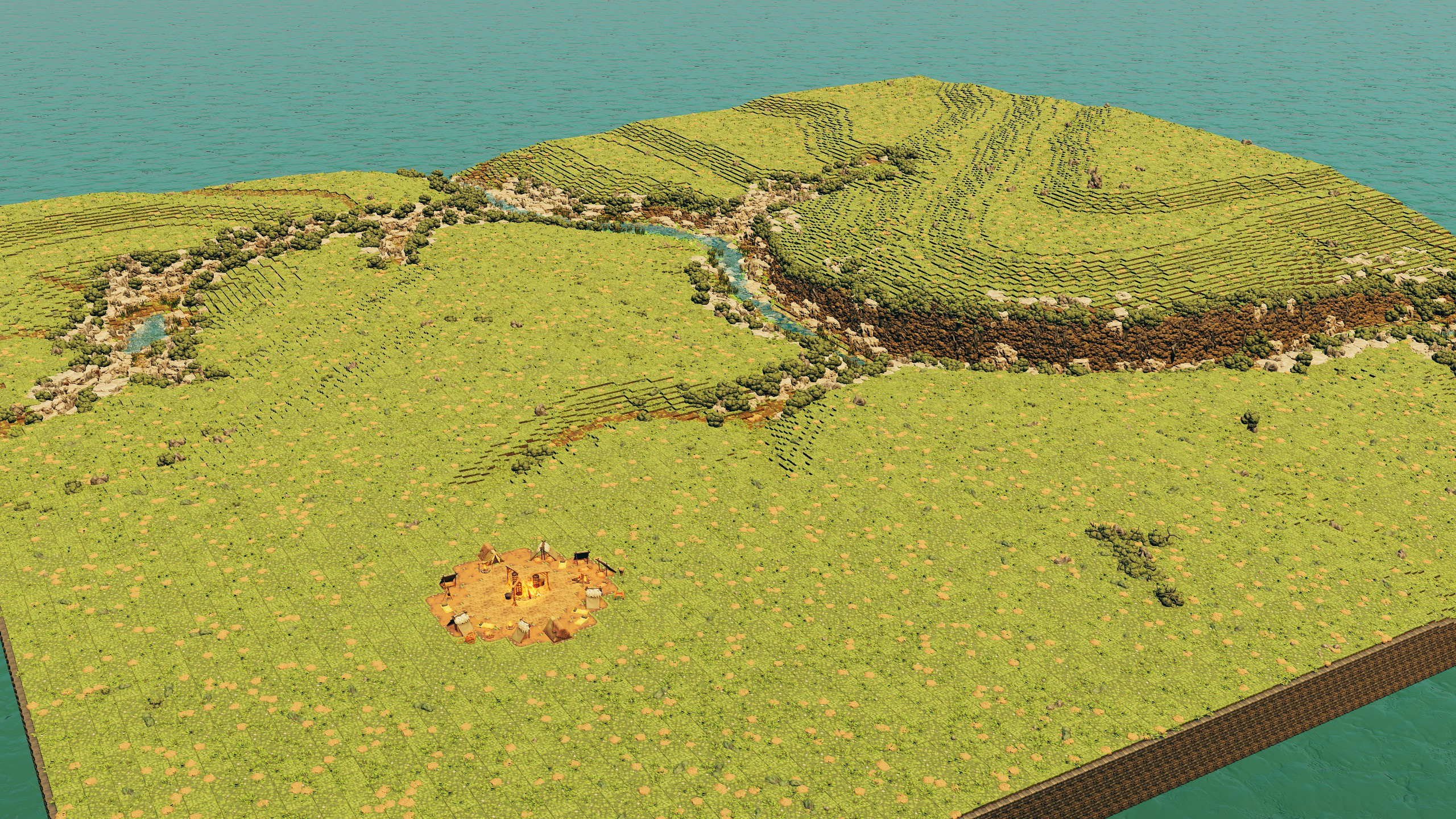 Overview of rolling grassy hills, a winding creek and a campsite